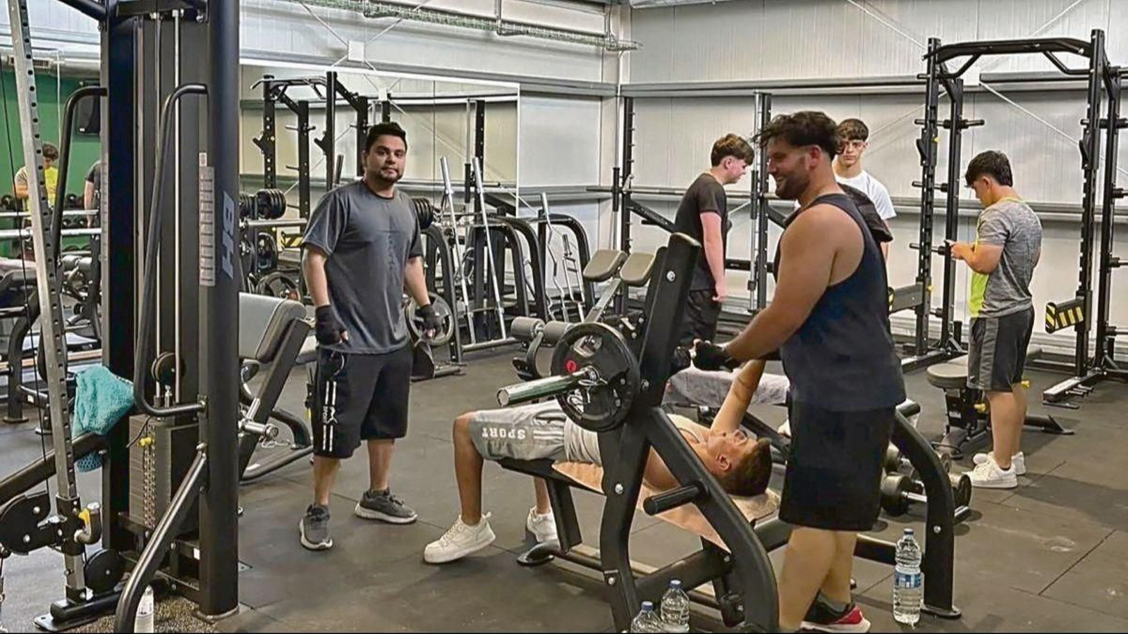Unos jóvenes realizan ejercicios en el gimnasio.