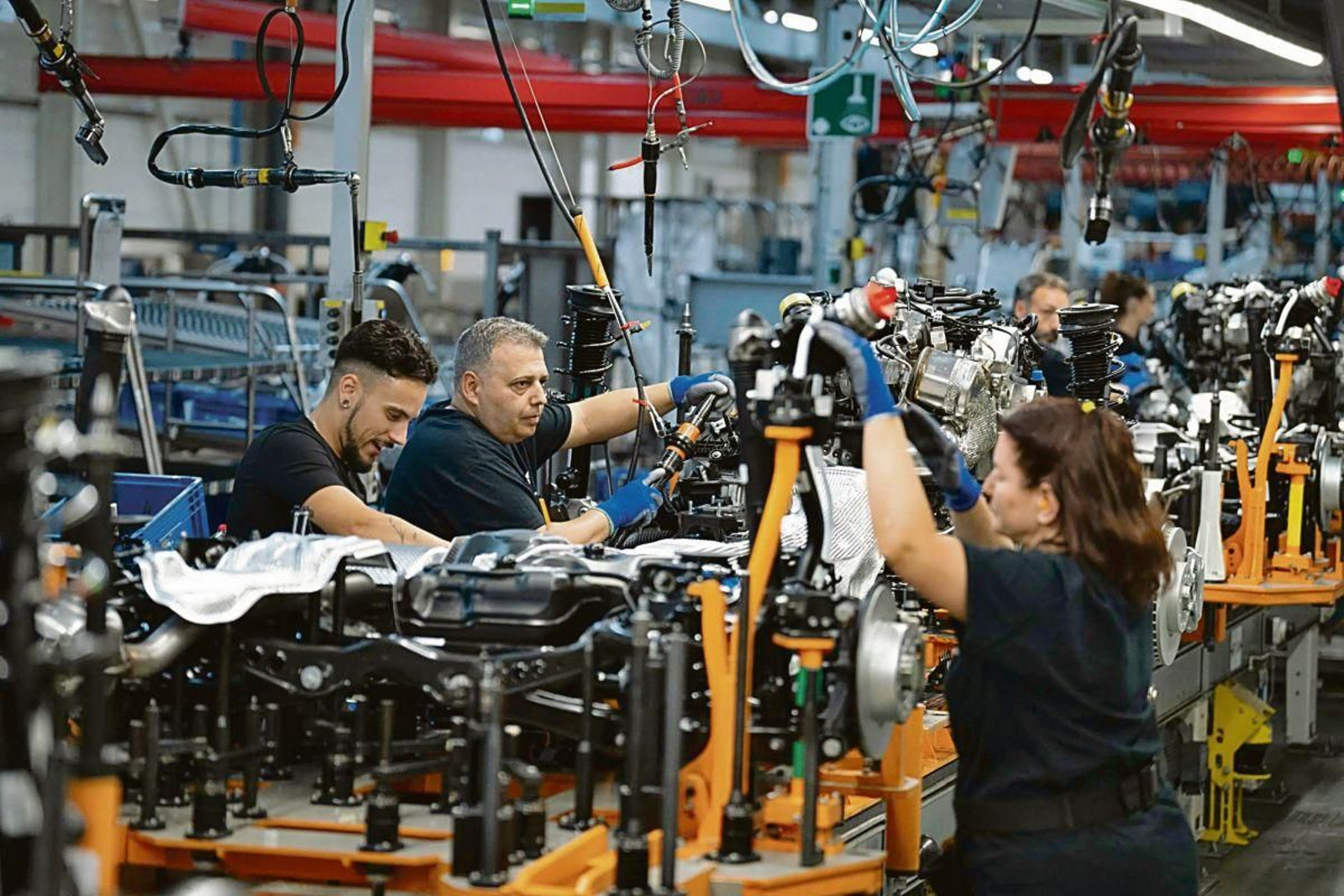 Trabajadores del sector del automóvil en una cadena de montaje.