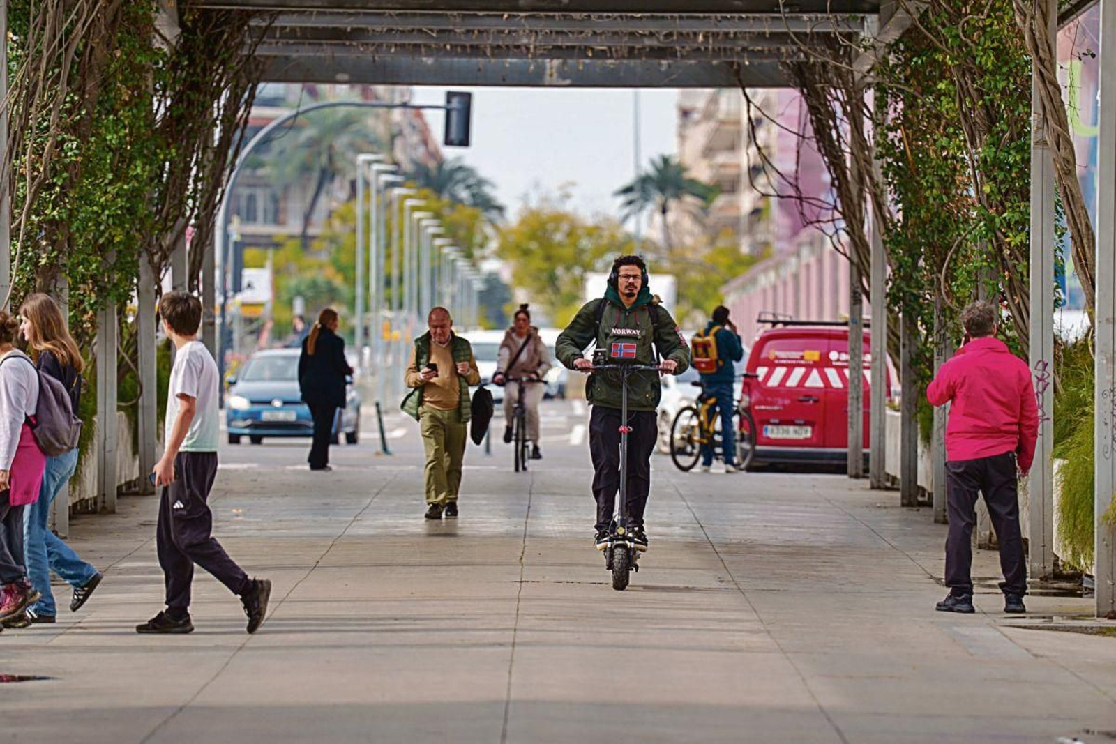 Un usuario de patinete eléctrico circula por una calle de Sevilla sin casco.