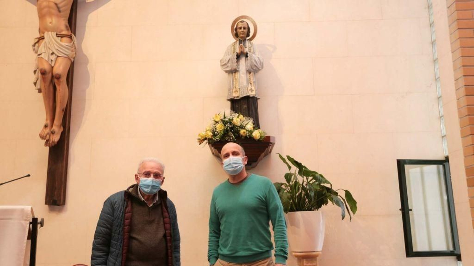 El anterior párroco de la iglesia, junto al actual, posan ante la imagen del Santo Cura de Ars.