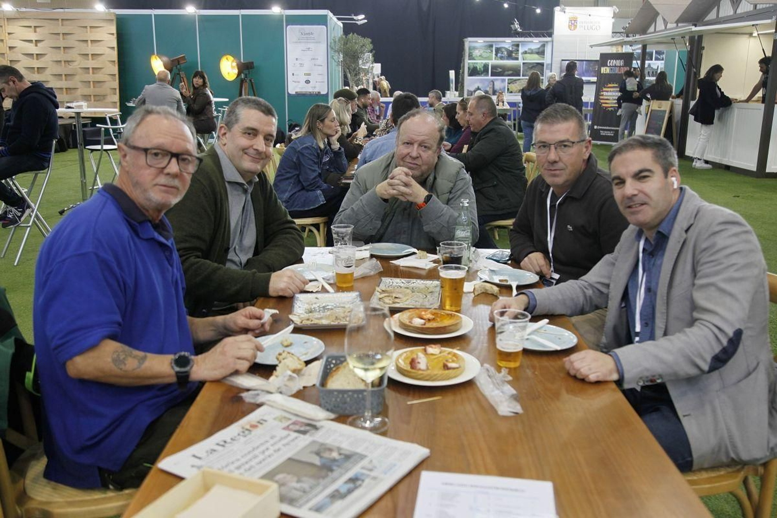 Agustín, José, Servando, Pablo y Pablo, rodeados de platos y del periódico.