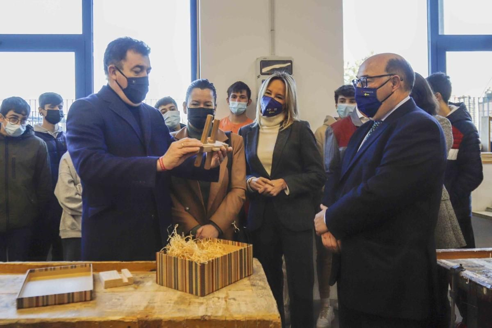 El conselleiro recibiendo un pequeño obsequio en el IES, junto a la alcaldesa. la delegada de la Xunta y alumnos.