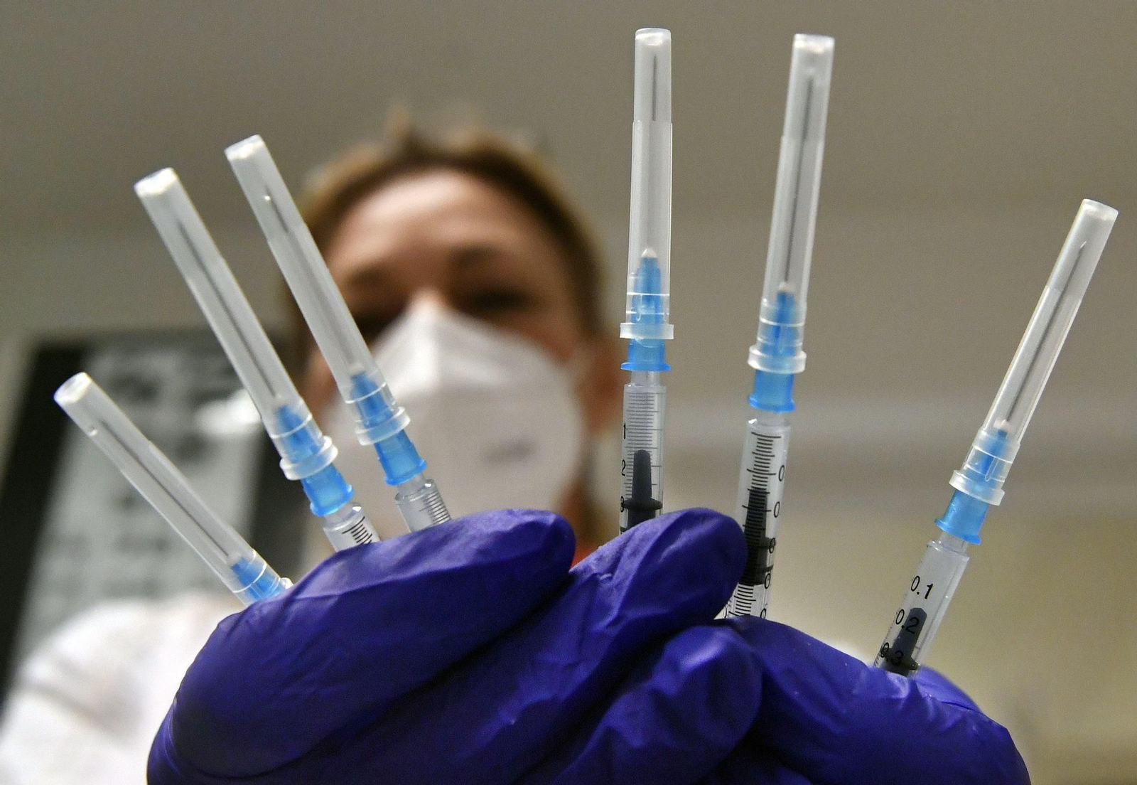 Una enfermera sostiene varias jeringuillas con dosis de Pfizer.