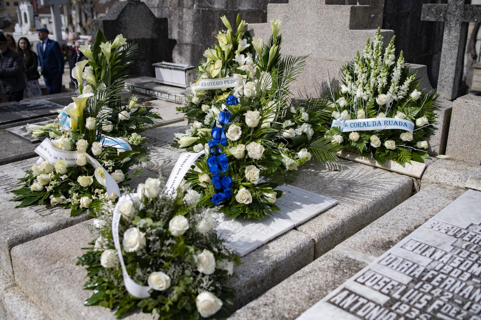 Las coronas florales de la Coral da Ruada y el IES Otero Pedrayo sobre la tumba de Don Ramón.