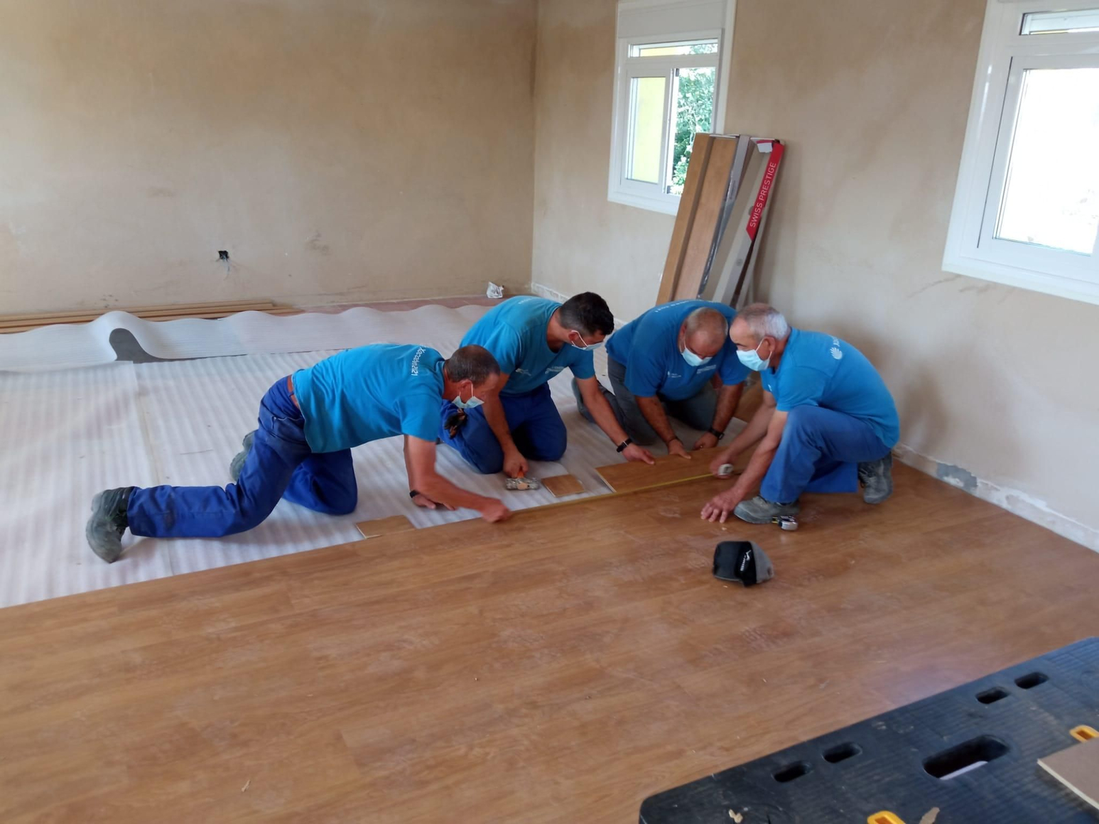 Los operarios colocando el parqué. (Foto: C.C.).