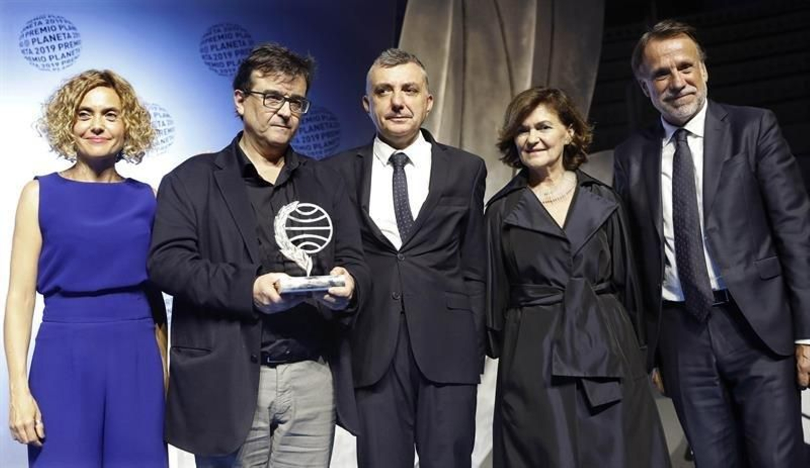 El escritor Javier Cercas (2i), ganador del LXVIII Premio Planeta de Novela con su obra "Terra Alta", y el finalista Manuel Vila (c), acompañados por el presidente de la editorial Planeta, José Creuheras (d), la vicepresidente del Gobierno en funciones Carmen Calvo (2d) y la presidenta del Congreso Meritxell Batet (i), esta noche tras recibir el galardón en Barcelona