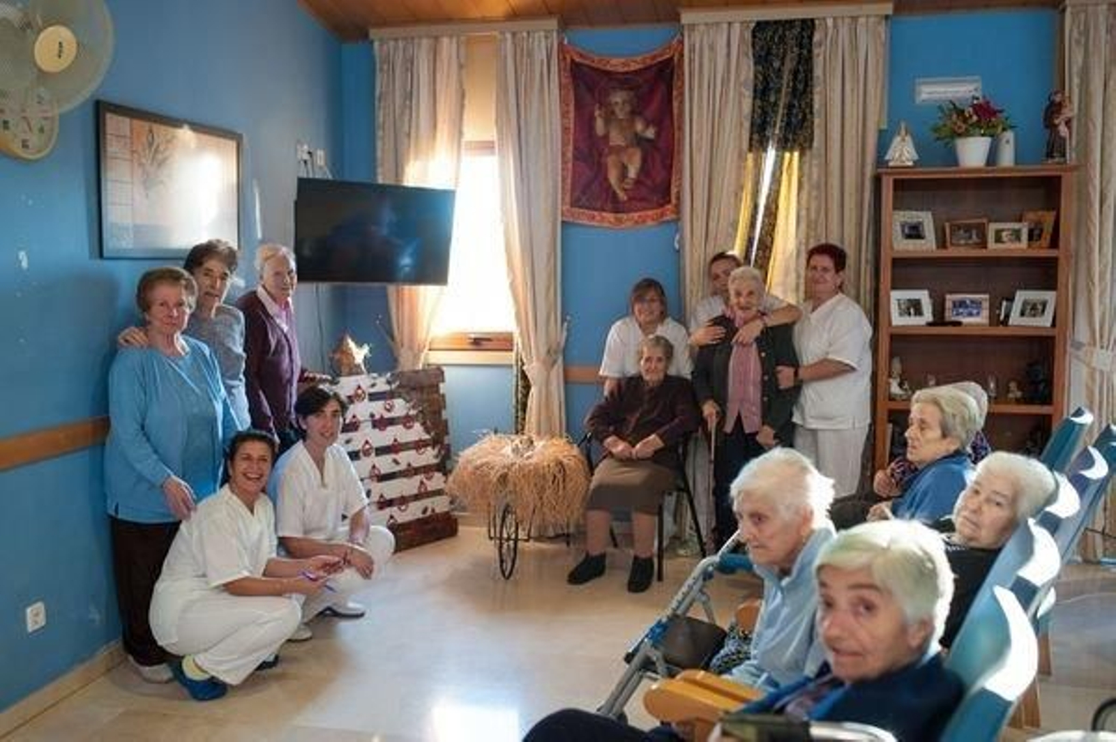Foto de familia de los miembros de la Residencia San Antonio con la decoración navideña.