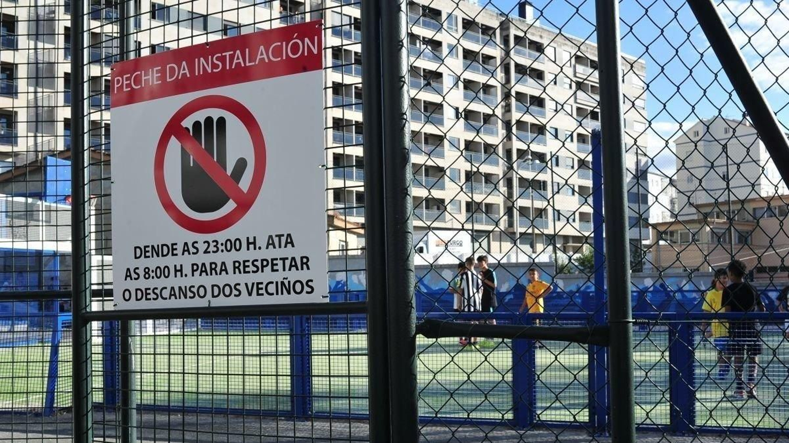 El cartel informativo sobre la medida del Concello de limitar el uso de algunas canchas de 8:00 a 23:00 horas, en A Cruz Alta. (Foto: José Paz)