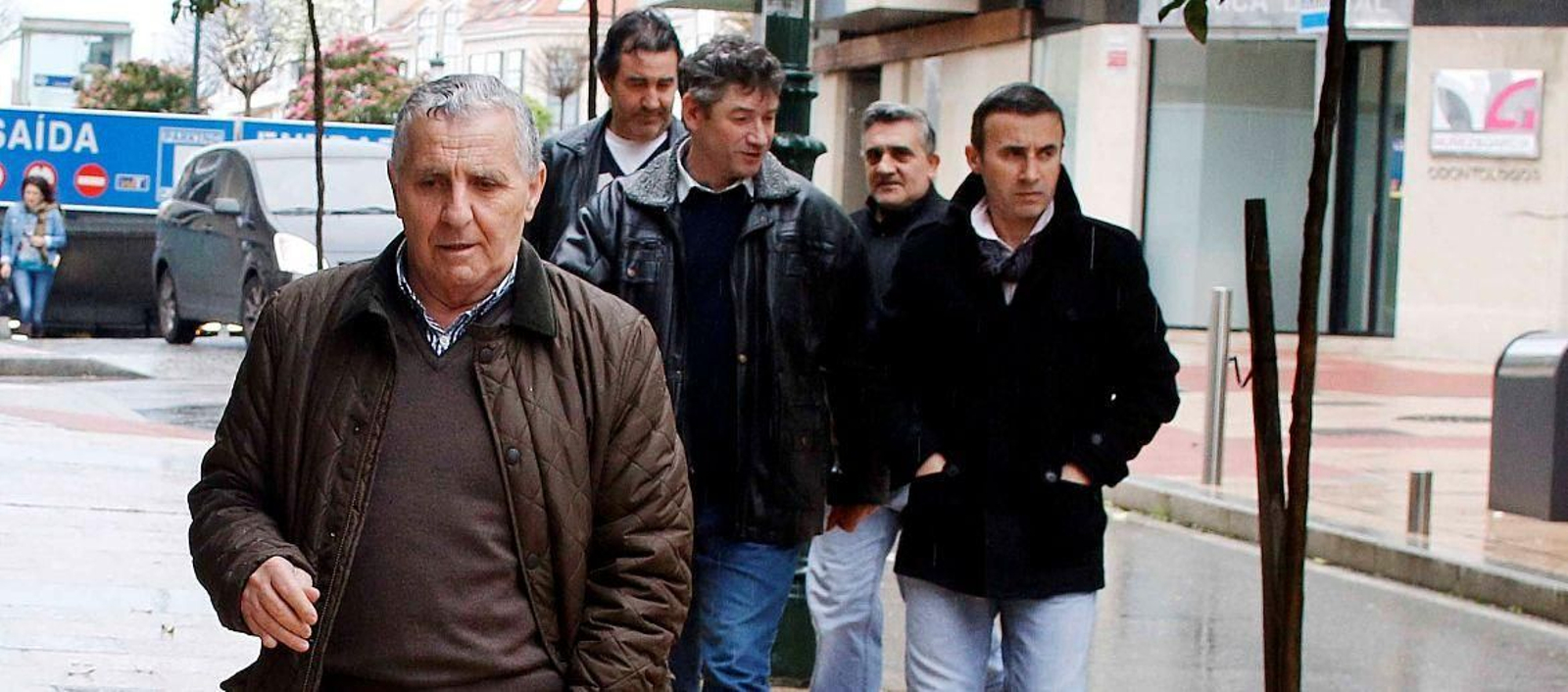 Un responsable de la armadora del "Mar de Marín", con los  cuatro marineros supervivientes del naufragio, ayer, al ir a declarar ante la Guardia Civil en Vigo. // JV Landín