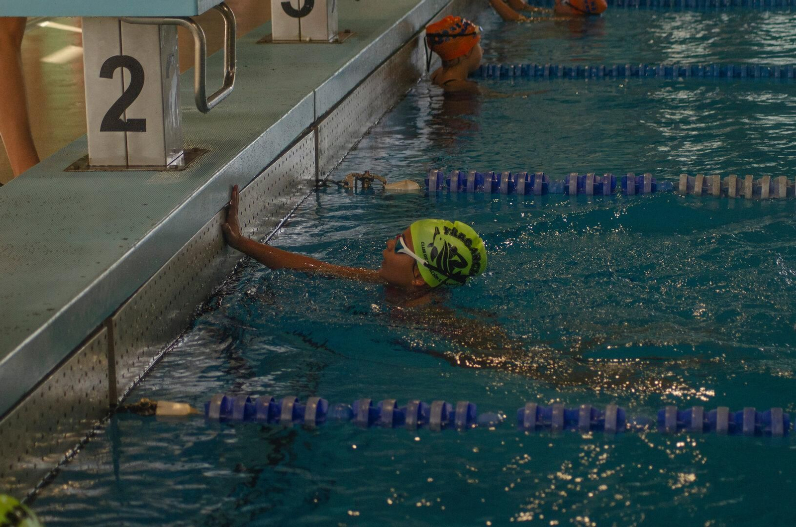 La satisfacción de alcanzar la meta después del esfuerzo realizado dentro de la piscina.