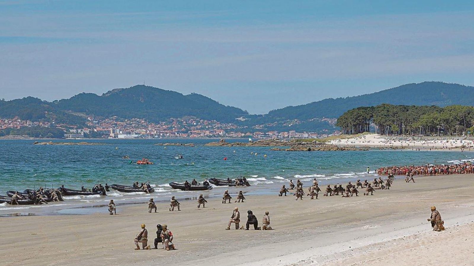 Una panorámica del desembarco de la flota en el momento en el que los oficiales de infantería llegan a tierra desde las lanchas y se posicionan esperando instrucciones. Se puede distinguir al público dentro de la playa que estaba separado de la zona militar por unas vallas.