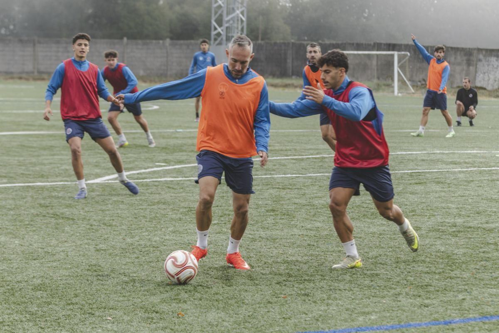 El unionista David Ferreiro aguanta la pelota, ante su compañero Xabi Domínguez, en un entrenamiento en el campo de Albán (Coles).