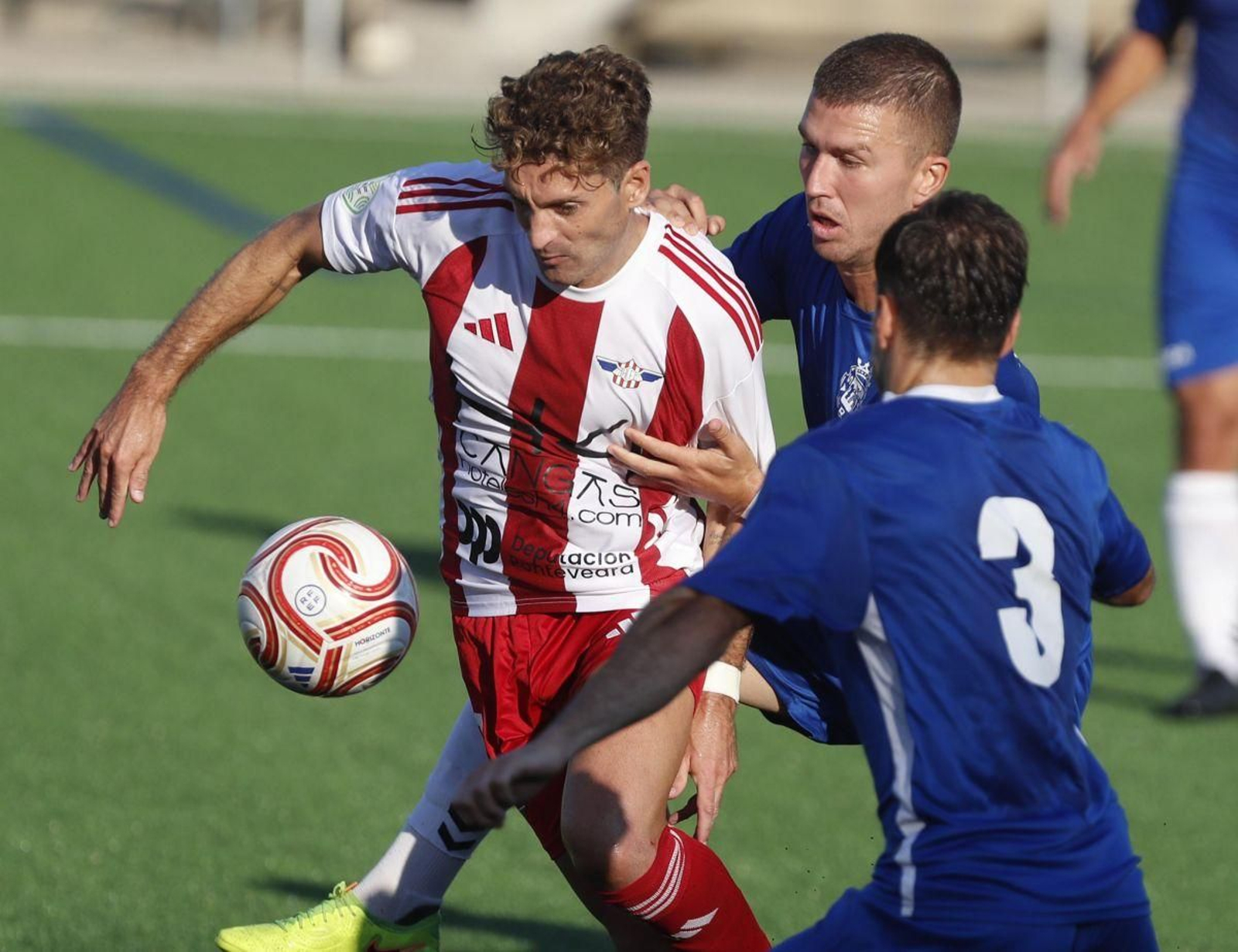 Un jugador del Alondras se libra de dos defensores de la Sarriana en la anterior jornada