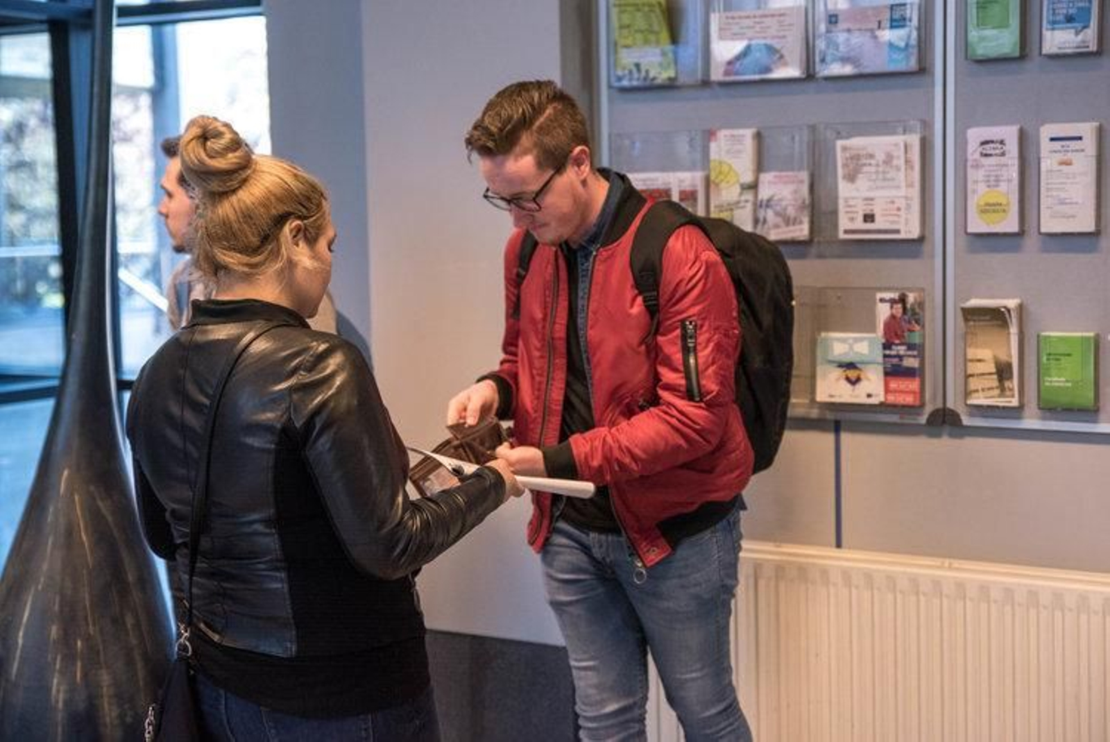 Una de las presuntas estafadoras iniciando el timo con un joven, dentro del edificio do Ferro.