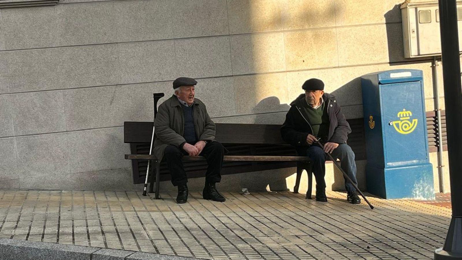 Dos mayores sentados en un banco.