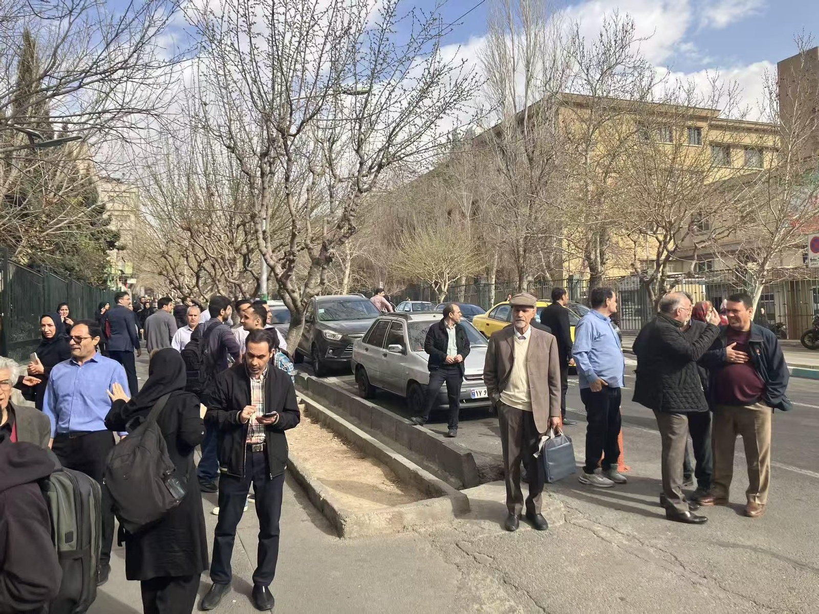 Personas siguiendo desde la calle los ataques en Teherán