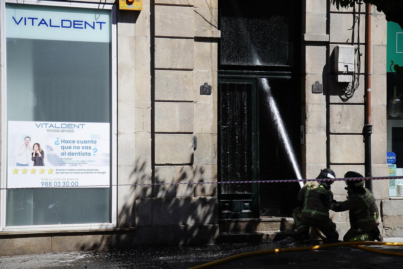 Los bomberos refrescan el edificio incendiado