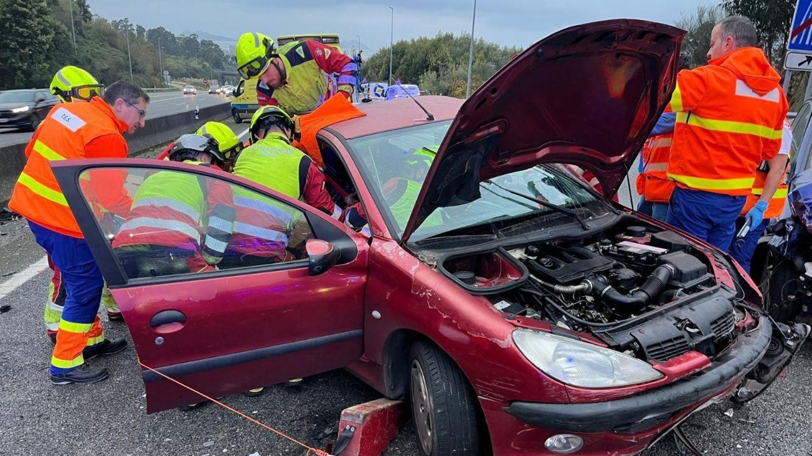 Bomberos y sanitarios en la liberación de la persona atrapada.