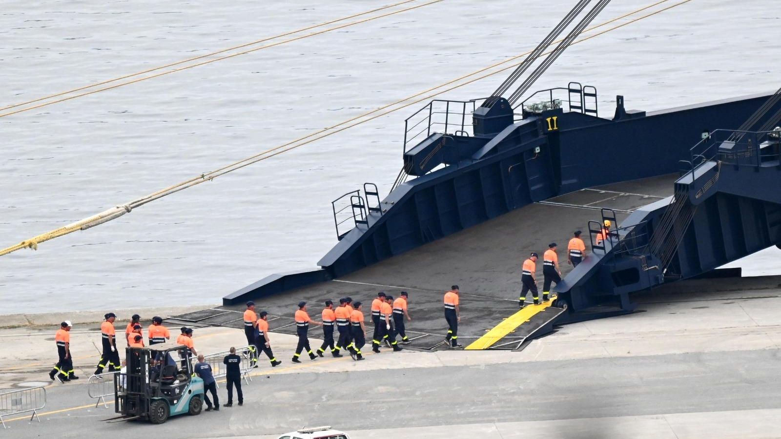 Operarios descargan los vehículos transportados por el Anji Forever en la dársena de Caneliñas.