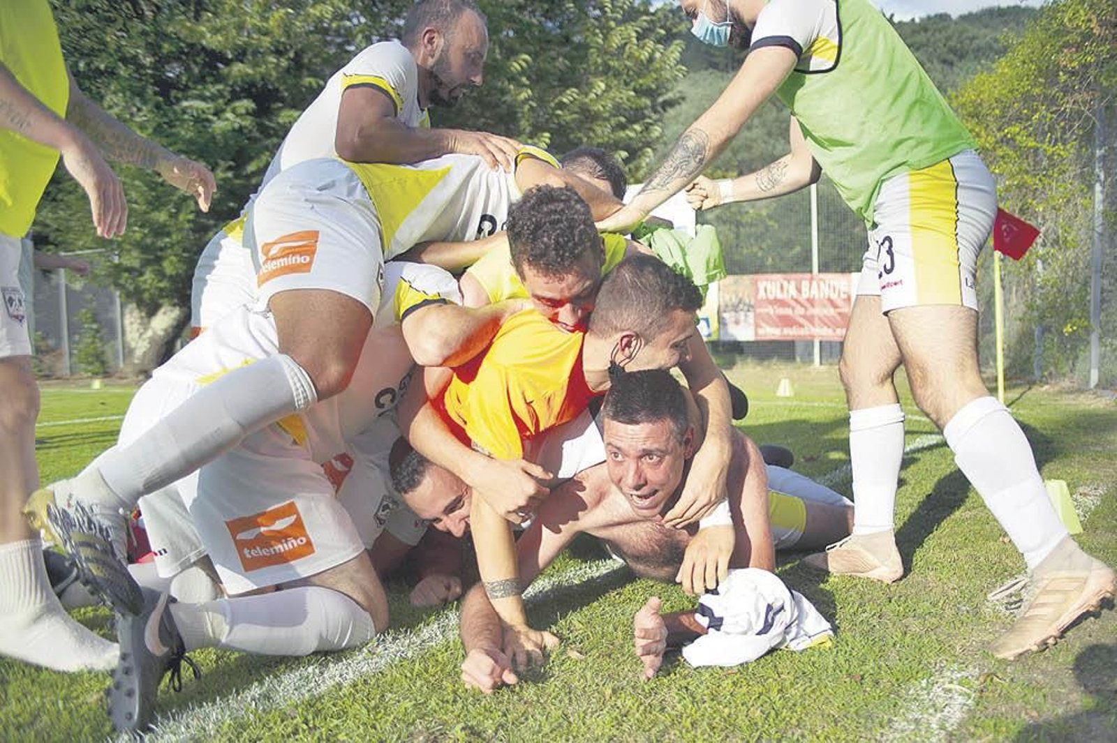 Los jugadores abrazan a Luchi, nada más conseguir el gol que vale un ascenso. (FOTO: MARTIÑO PINAL)