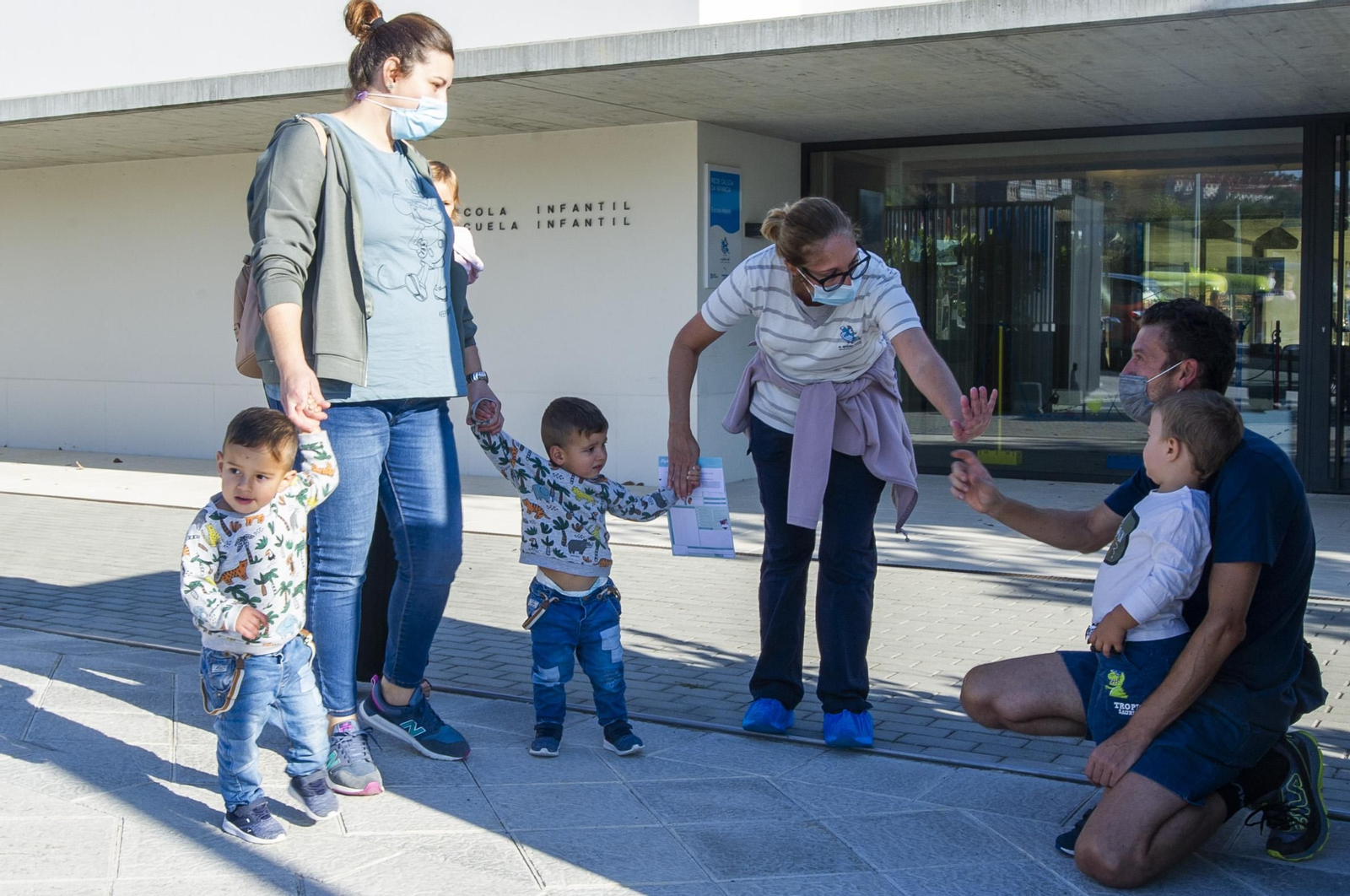Un grupo de padres accede ayer con los niños a la escuela infantil del Centro Intergeneracional de A Farixa.
