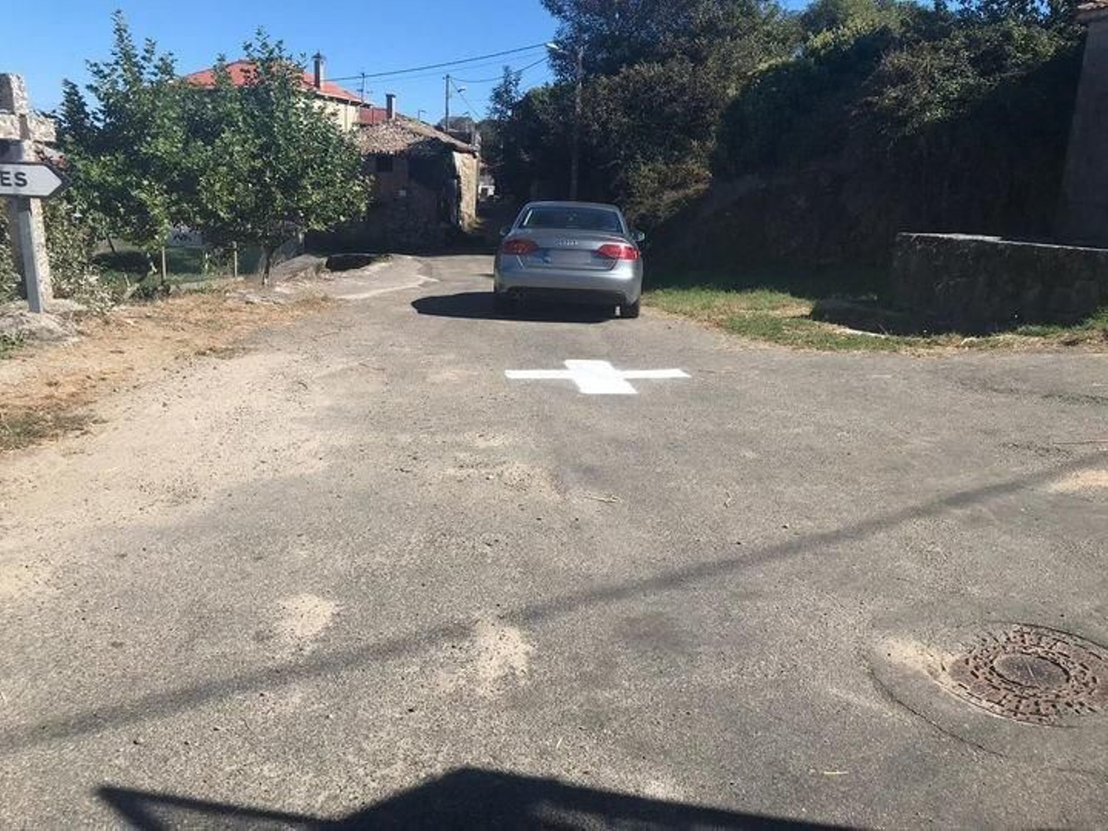 Un coche rebasa una de las cruces pintadas en cuatro carreteras del concello de Porqueira.