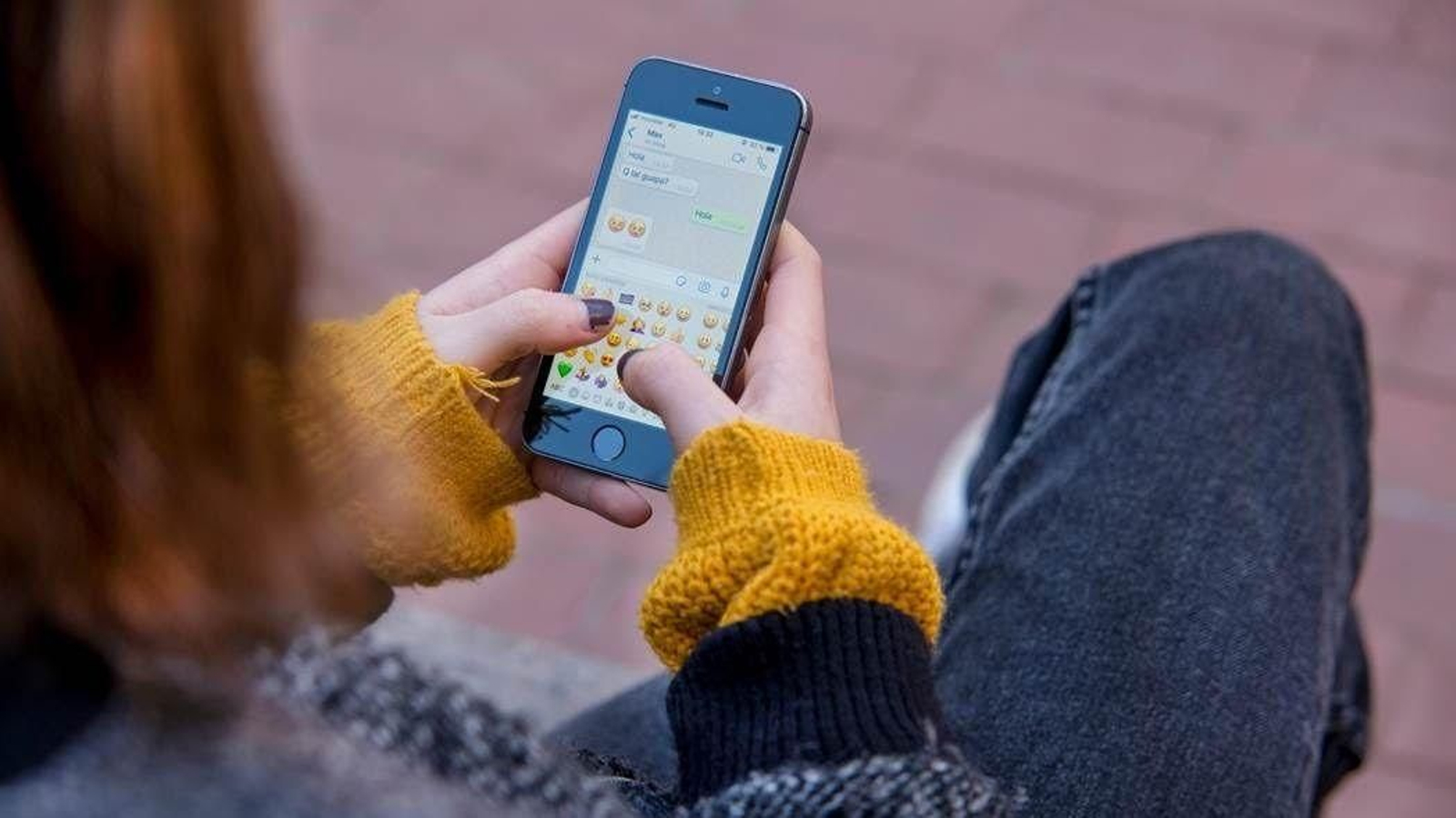 Una menor consulta el teléfono móvil.