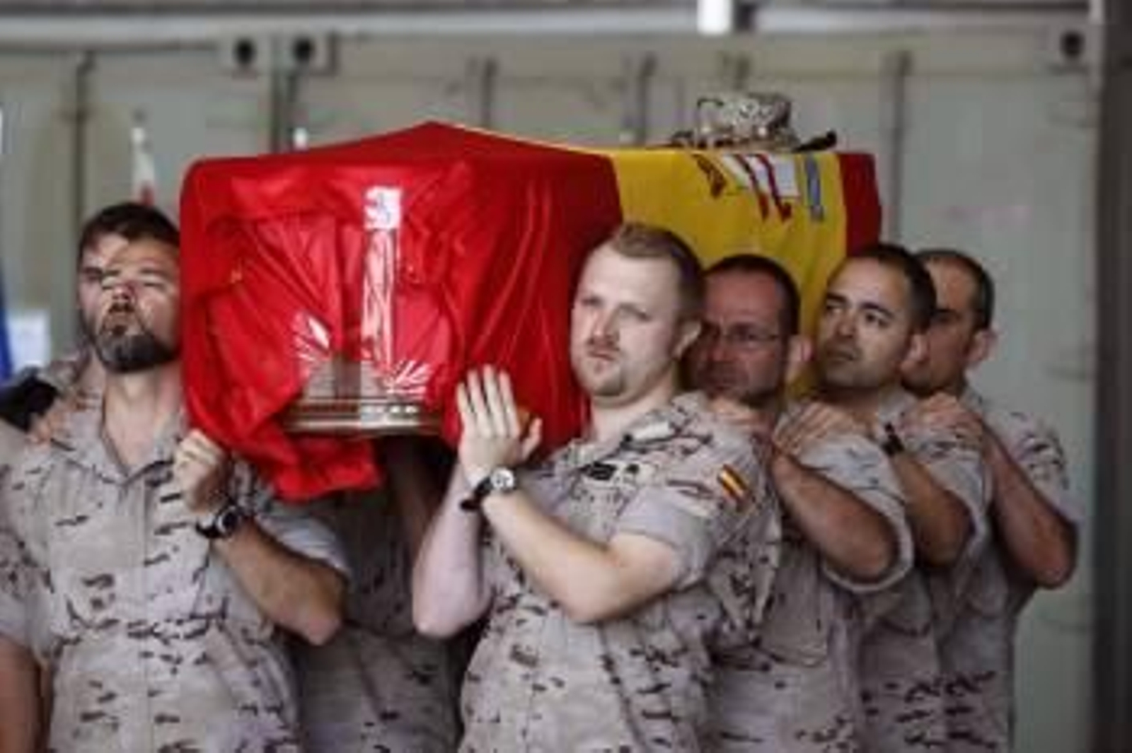 Soldados españoles trasladan a hombros el féretro con los restos mortales del sargento Manuel Argudin Perrino, uno de los dos fallecidos ayer en un atentado en Afganistán. (Foto: EFE)
