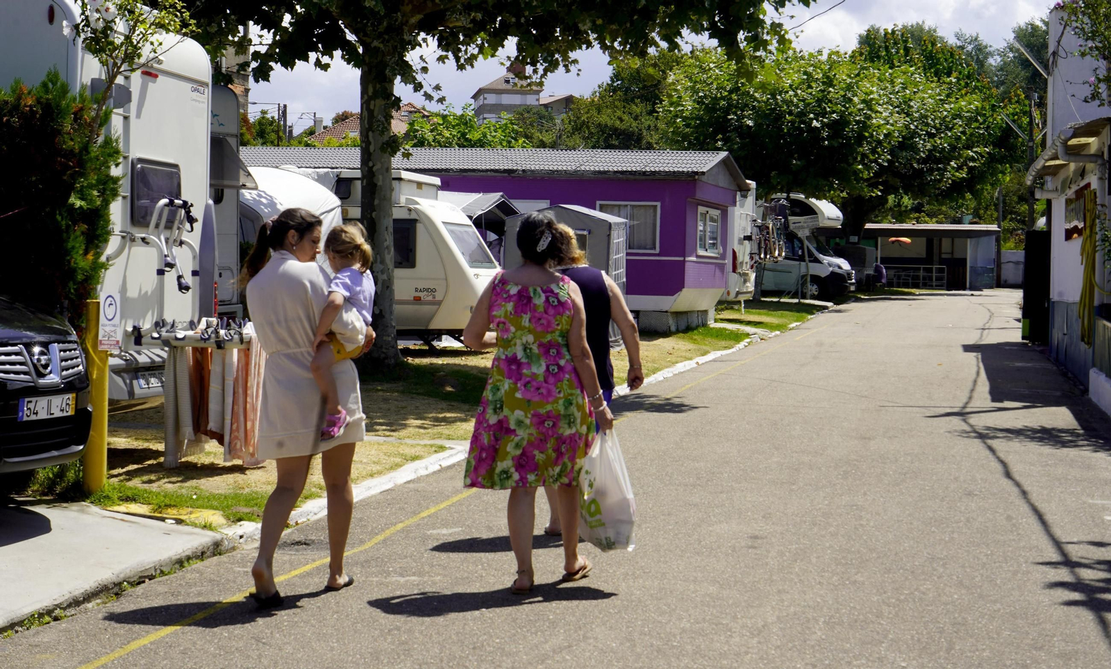 Un grupo de usuarios yendo hacia la parcela reservada en el Camping Samil, ubicado enfente del arenal.