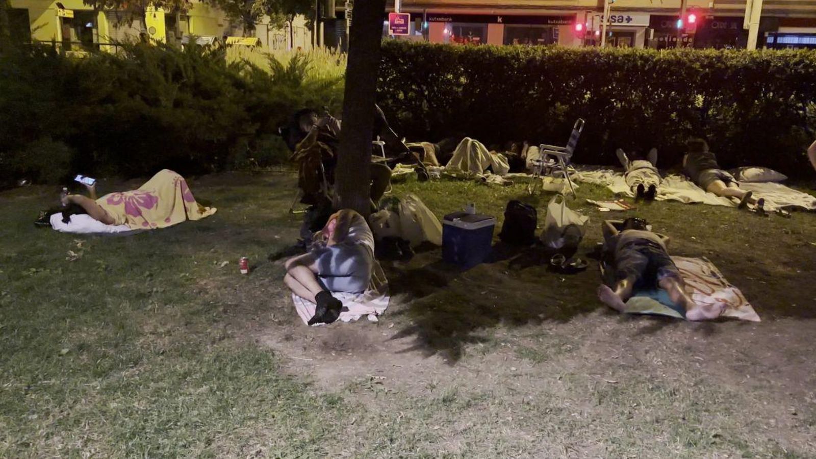 Varias personas duermen en un parque en Granada.