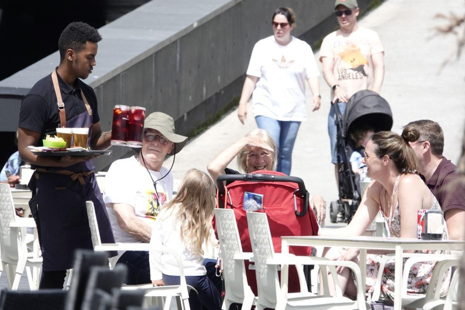 Un trabajador de la hostelería atendiendo una mesa en una terraza de Vigo.