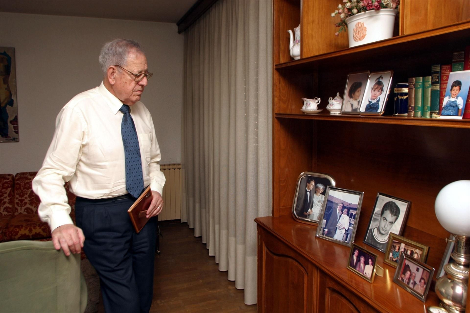 Juan Rodríguez, padre de José Luis Rodríguez Zapatero, en su casa mirando fotos en las que aparece el expresidente. (Archivo, 2001)