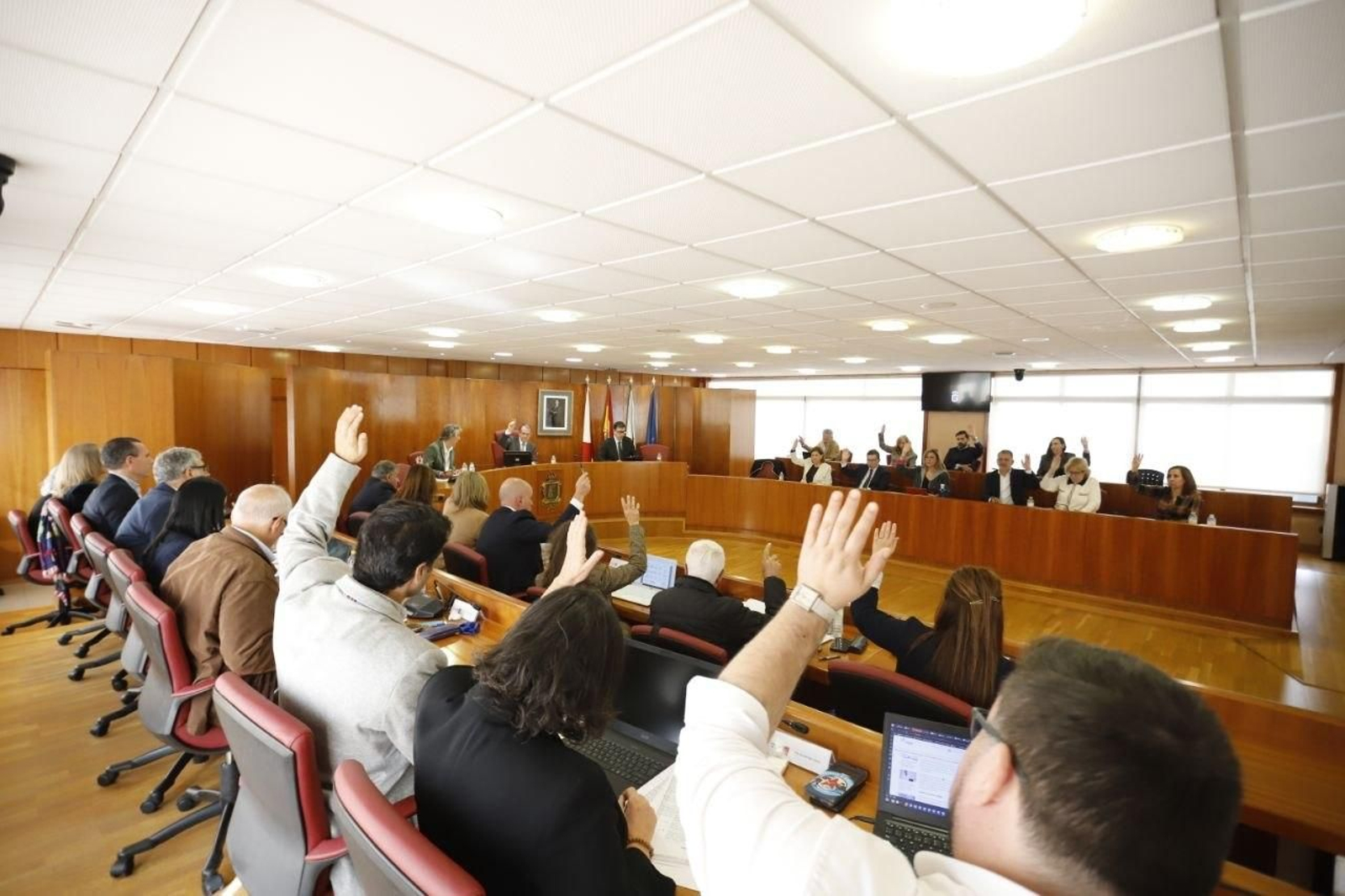 Concejales ade PSOE y BNG alzando la mano para votar durante el pleno municipal.