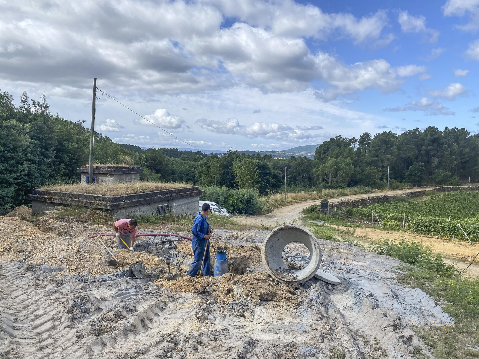 Dos operarios trabajan en la construcción de pozos en Mourazos, Verín.