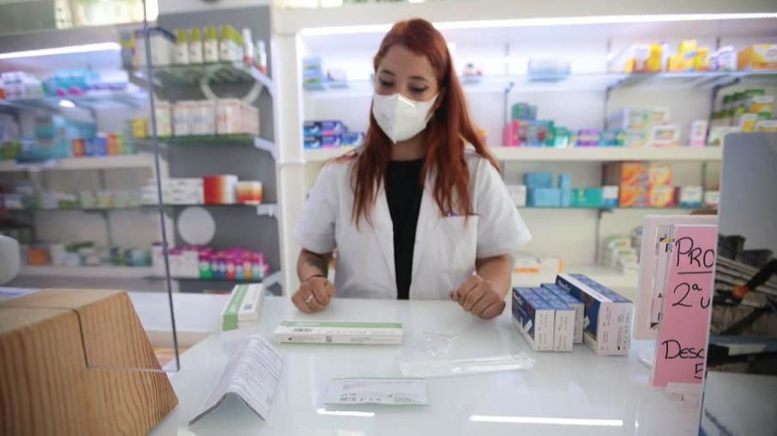 Noelia, de la Farmacia Carrascal, enseña los contenidos del test de autodiagnóstico de antígenos.
