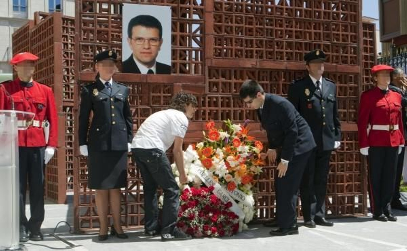 Los dos hijos de Puelles colocan una corona de flores en recuerdo de su padre. (Foto: David Aguilar)