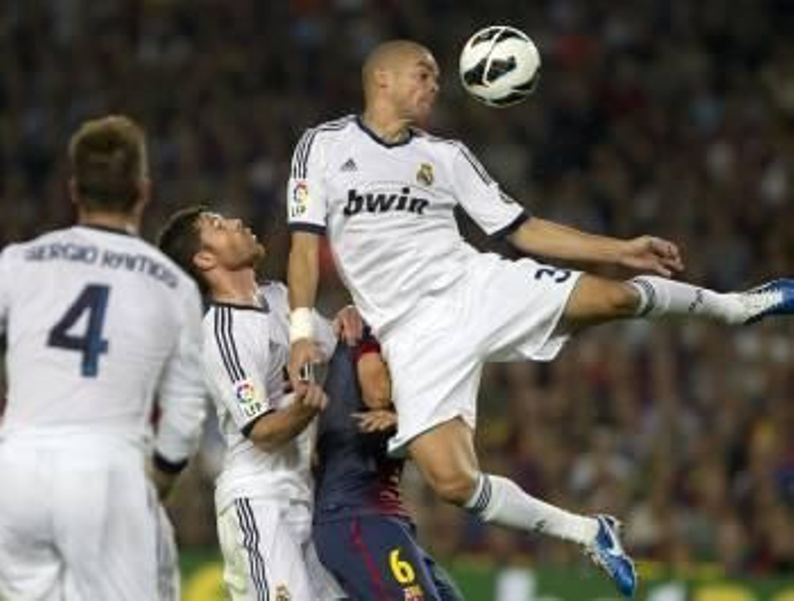 Xavi, emparedado entre los jugadores del Madrid Sergio Ramos, Xabi Alonso y Pepe. (Foto: ALEJANDRO GARCÍA)