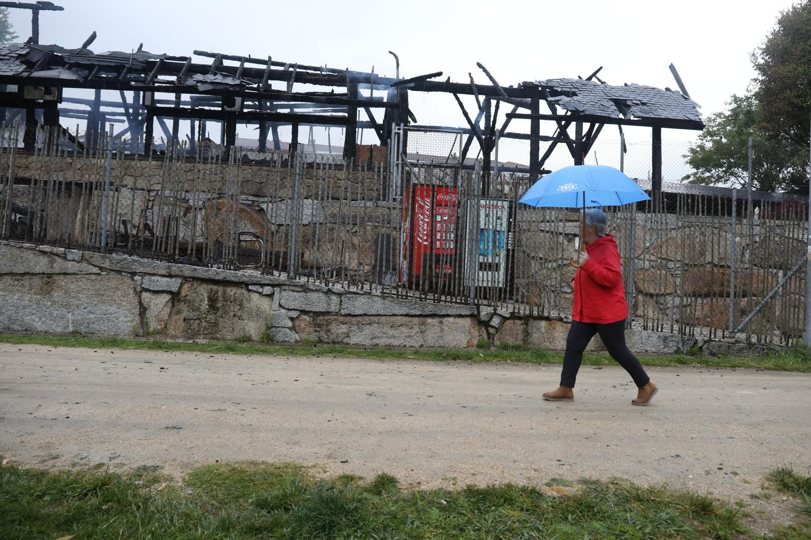 Una vecina observa el esqueleto del balneario, una vez sofocado el incendio. Numerosos curiosos acudieron durante el día al lugar.