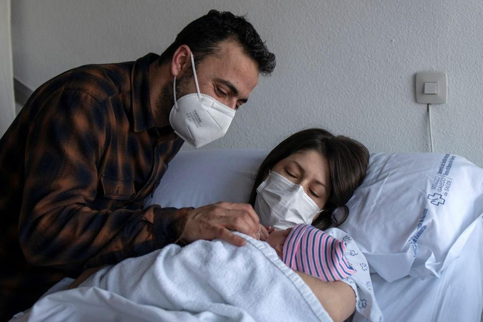 Una pareja posa con su hijo recién nacido.