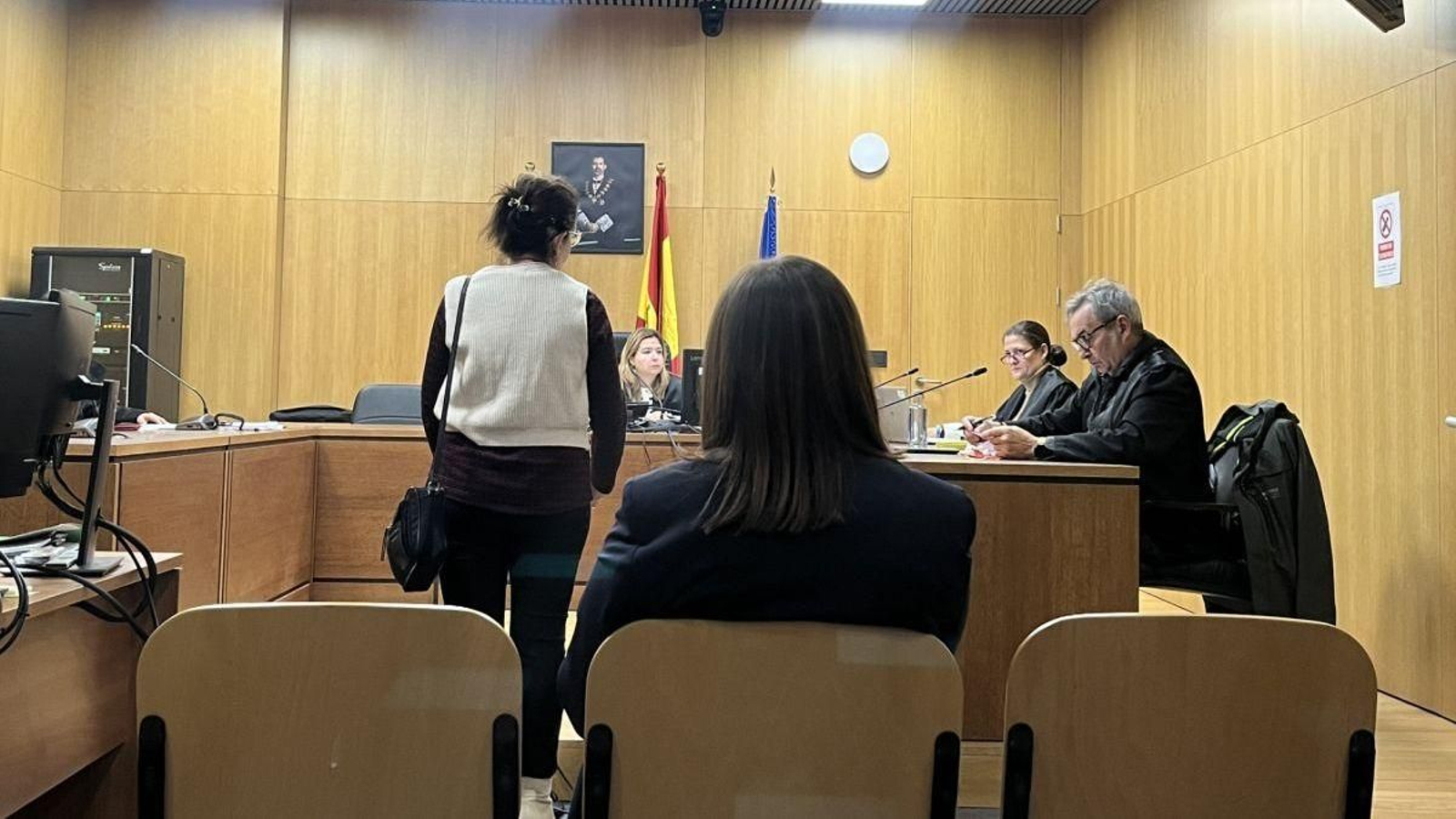 La denunciante (de pie) y la acusada (sentada).