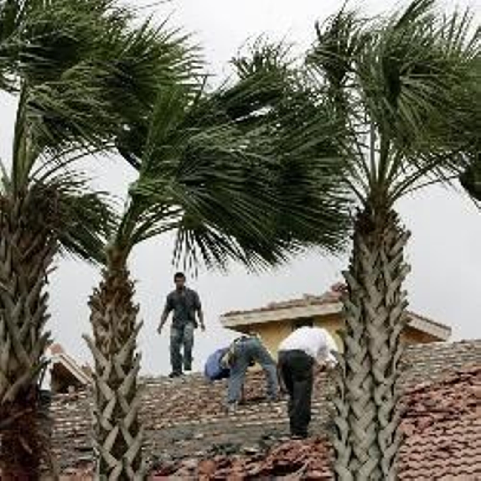 Varias personas esperando auxilio en un tejado.