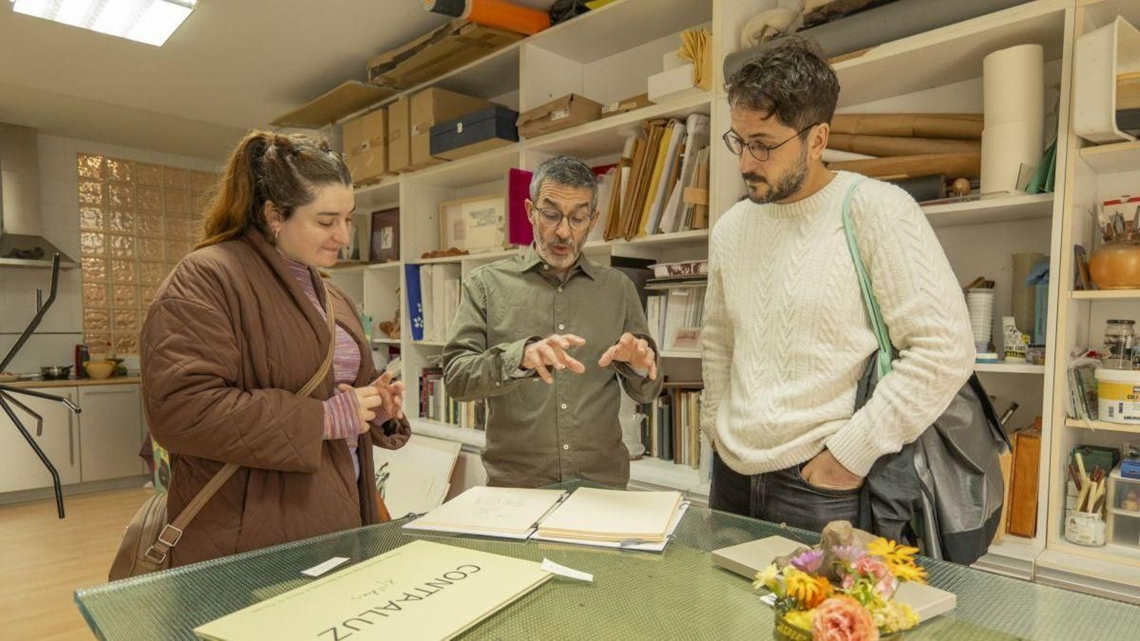 Xosé Poldras mostrando su trabajo a visitantes interesados.