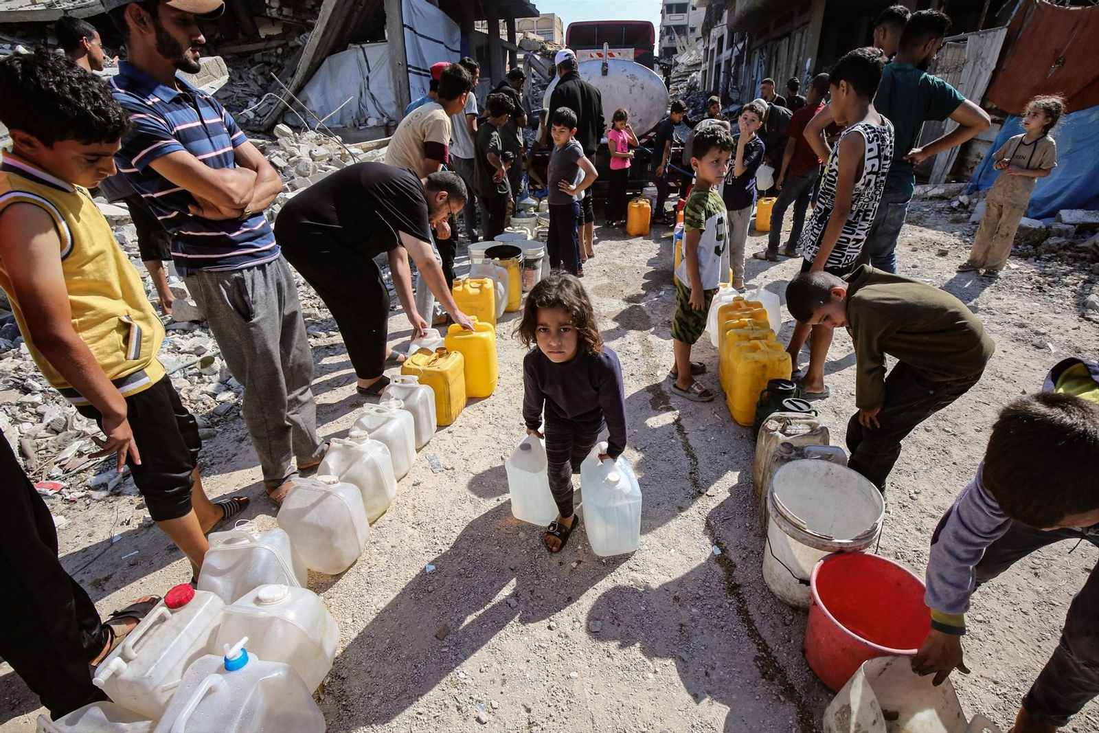 Una nila carga con dos bidones de agua.