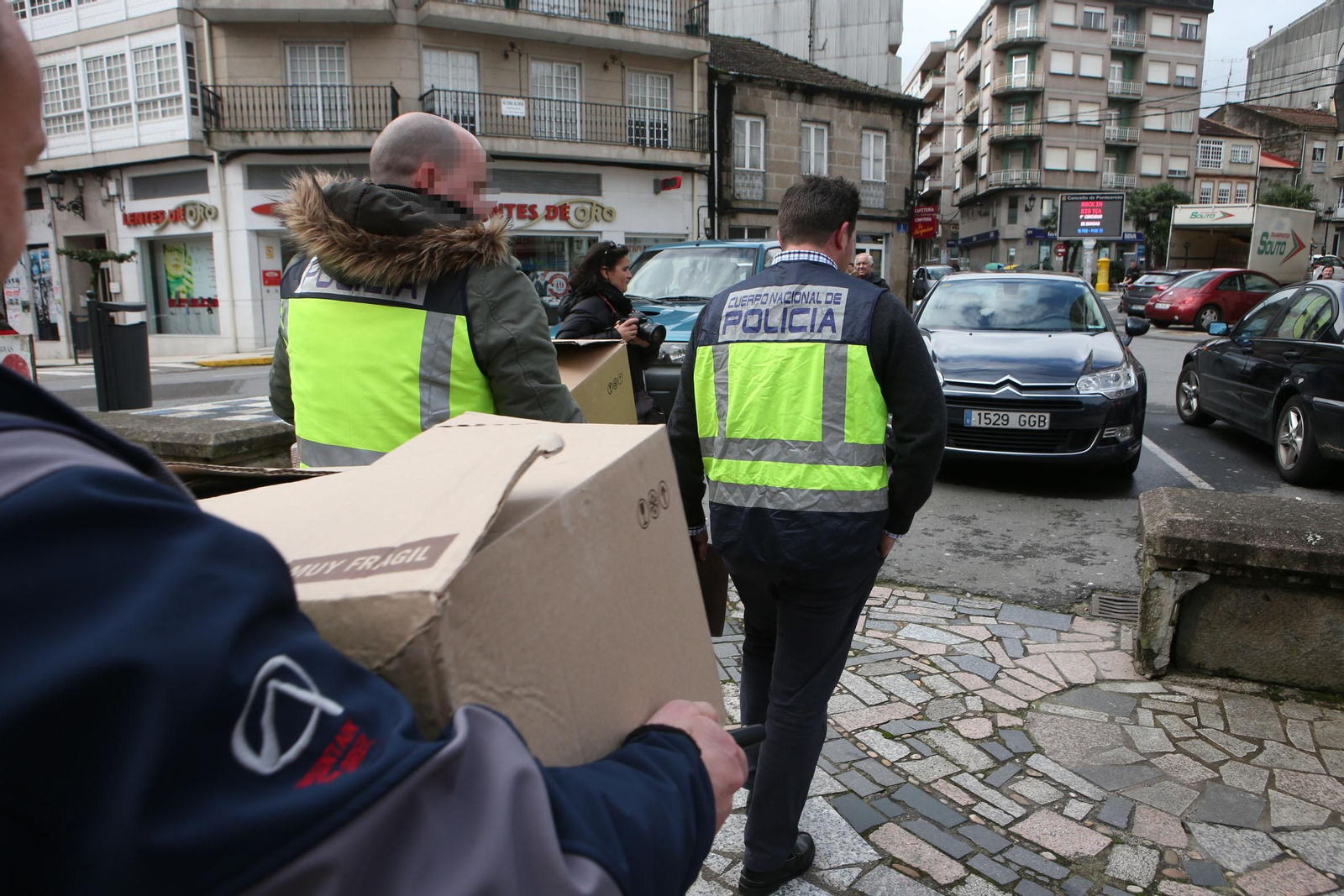 Agentes de Policía a su salida del Ayuntamiento de Ponteareas con el material requisado