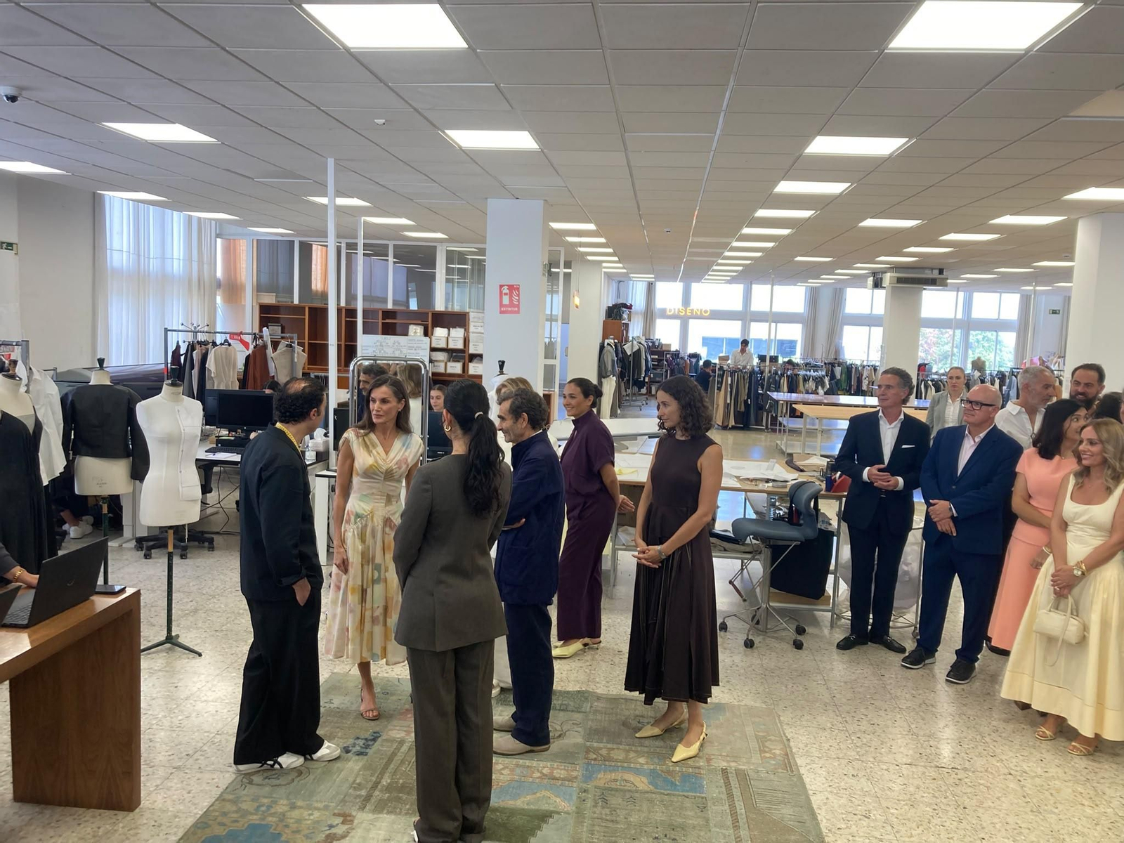 Uno de los diseñadores de Adolfo Domínguez explica en el taller a la reina Letizia las novedades en los diseños de la marca.