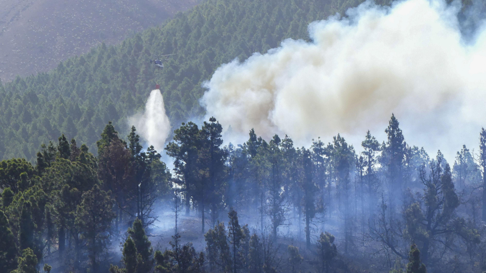 Un helicóptero descarga agua sobre el fuego que comenzó el miércoles en el municipio de El Paso.