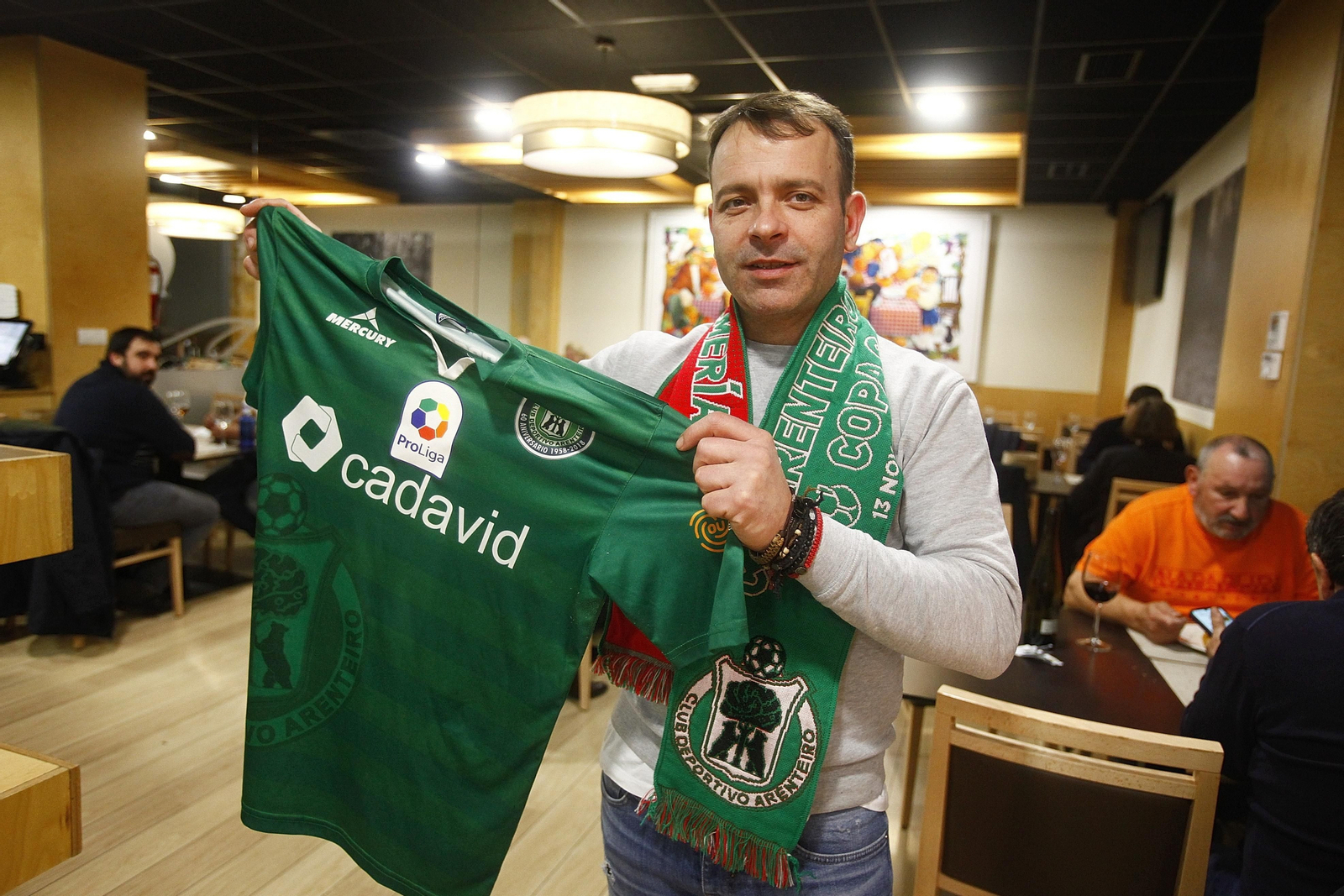 César Álvarez, del restaurante Fuchela, exhibe camiseta y bufanda de apoyo al Arenteiro. (MIGUEL ÁNGEL)