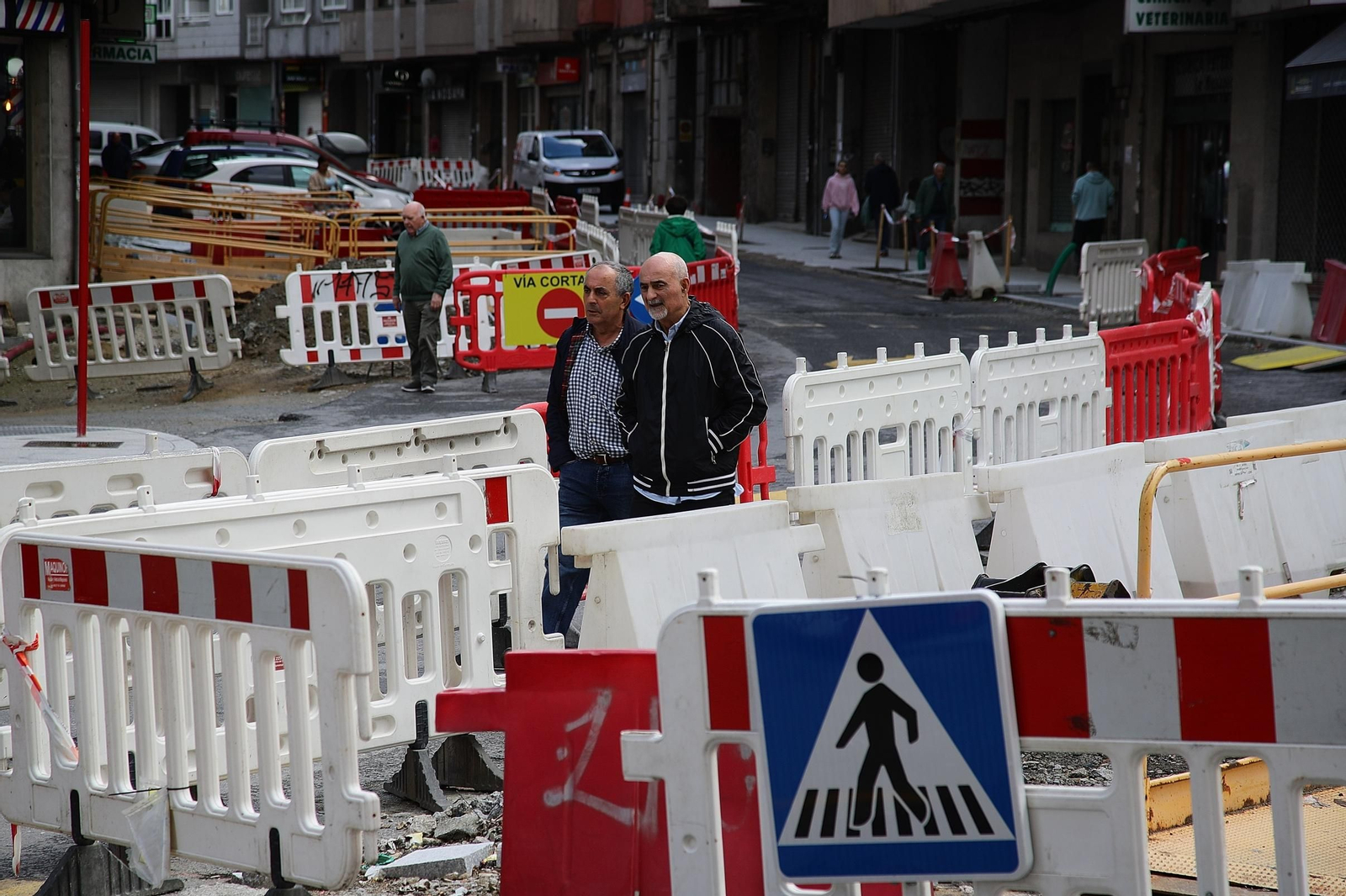 Dos vecinos sortean las vallas de la calle en obras