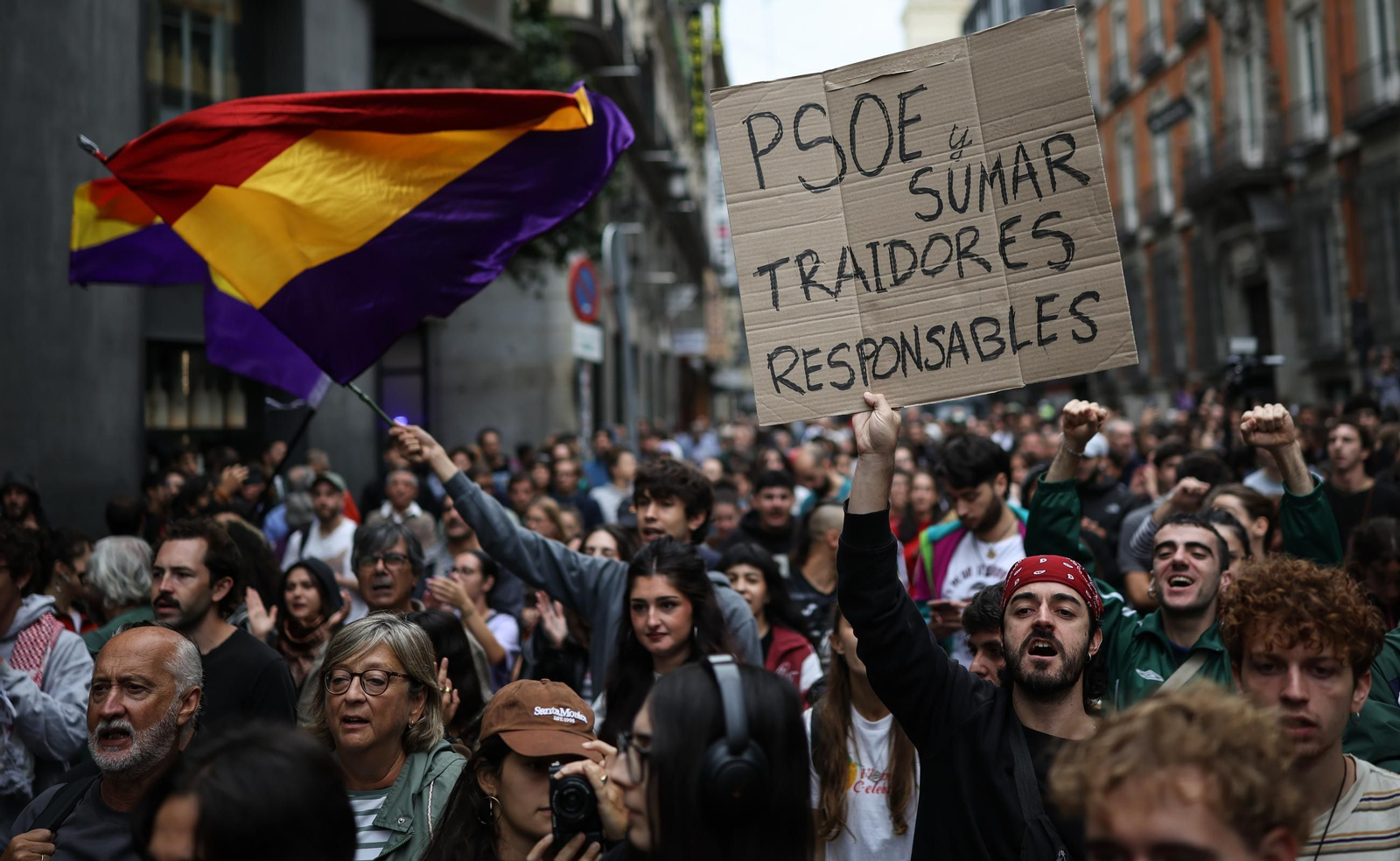 Manifestantes concentrados ante el cordón policial desplegado en los aledaños del Congreso de los Diputados durante la protesta en defensa del derecho a la vivienda