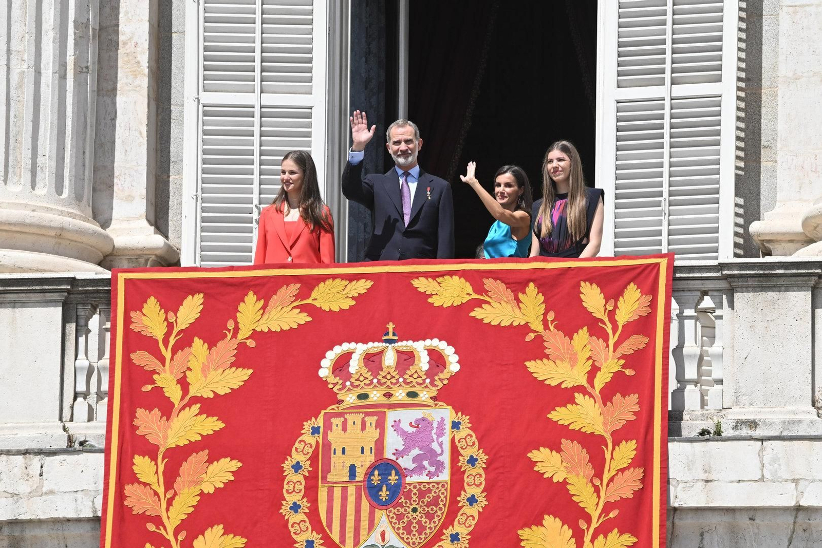 Los Reyes y sus hijas saludan desde el balcón del Palacio Real.